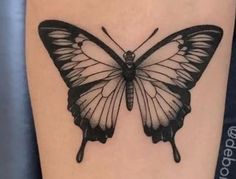 a black and white butterfly tattoo on the leg