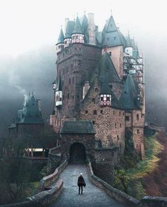 a person standing in front of an old castle