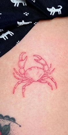 a small crab tattoo on the back of a woman's shoulder