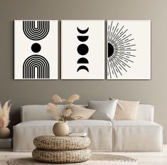 two black and white art prints on the wall above a couch in a living room