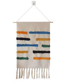 a white wall hanging with multicolored fringes