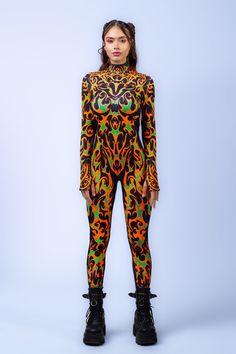 Set the main stage ablaze with our Scorching Costume. Escape the winter chills in this too-hot-to-handle one-piece. Crafted from a stretchy, sculpting fabric and complete with attention grabbing fiery motifs that follow the curves of your body, this design is made for standing out. You can play with layering or wear it solo, trust us it won't disappoint. Pairs well with your favorite platform boots. FEATURES: > Mock Neckline  > Robust & Hidden Front Zipper Closure  > Long Sleeves >82% Polyester 18% Elastane  > Non-Transparent Lycra  > 30° Cold Wash, Hang dry Festival Vibes, Mock Neckline, Platform Boots, How To Better Yourself, The Winter, Front Zipper, Layering, Long Sleeves, One Piece