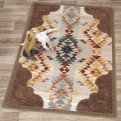 an area rug on the floor with a cow skull and other items in front of it