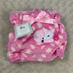 a pink blanket with a deer on it and a tag attached to the back of it