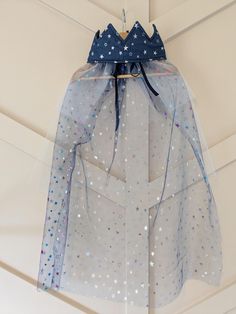 a blue and white dress hanging from the ceiling with stars on it's back