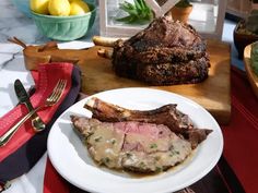 a plate with some meat and gravy on it next to other food items