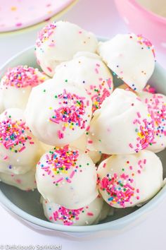 a bowl filled with white and pink sprinkles on top of a table