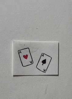 two playing cards with hearts and spades drawn on them