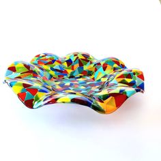 a colorful glass bowl sitting on top of a white table