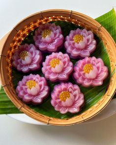 some pink flowers are in a basket on a table