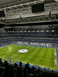 an empty stadium filled with people watching a soccer game on the field in front of them