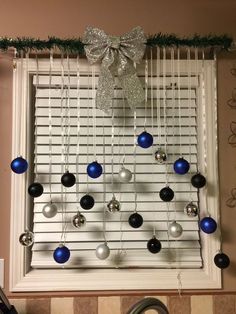 a window with ornaments hanging from it's side and a bow on the top