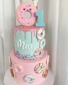 a birthday cake decorated with donuts and sprinkles for a one year old