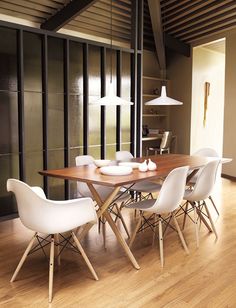 a dining room table with white chairs around it