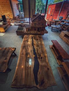 a table made out of wood in a room with lots of benches and tables around it