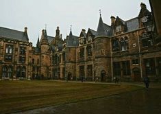 an old building with lots of windows and green grass