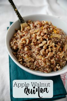 a white bowl filled with granola on top of a blue napkin next to a fork