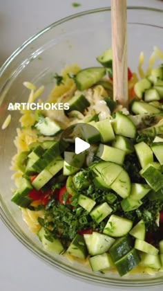 a glass bowl filled with cucumbers and other vegetables