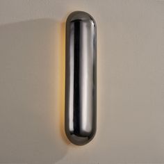 a metal object mounted to the side of a wall with a light on it's side