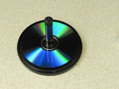 a black disk with a green and blue disc on it sitting on a counter top