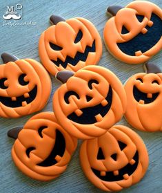 pumpkins with faces carved into them sitting on a table