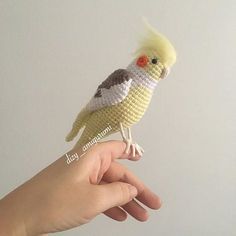 a hand holding a small toy bird in it's palm