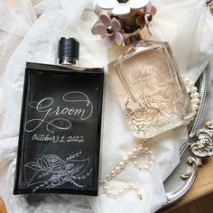 a bottle of perfume sitting on top of a table next to a plate with pearls