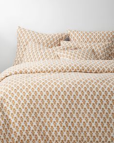 an orange and white bedspread on a bed