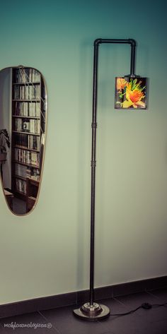 a room with a book shelf and a large mirror on the wall next to it