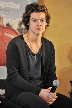 a young man sitting in front of a microphone