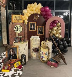 balloons and pictures are on display in front of the entrance to a party room with black, gold and white decorations