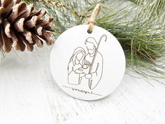 a ceramic ornament with a drawing of a man and woman holding a baby