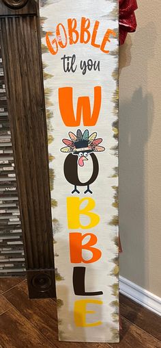 a wooden sign that says, gobble til you whapple with an image of a penguin wearing a hat