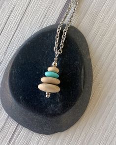 Cairns have long been used to mark trails and paths so that we don’t lose our way in the wilderness. Take a little bit of the trail with you wherever you go with this dainty cairn necklace. Three hand drilled pebbles and a heishi glass bead are hung on small stainless steel chain. Comfortable and easy to wear. Stainless steel chain and findings won’t tarnish, and won’t irritate sensitive skin. -Stainless steel findings and chain -Hand drilled natural beach pebbles and a turquoise glass heishi be Cairn Necklace, Beach Pebbles, Beige Flats, Turquoise Glass, Heishi Beads, Cairns, The Wilderness, The Trail, Long Chain