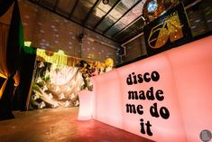 disco made me do it sign lit up in the middle of a room with lights