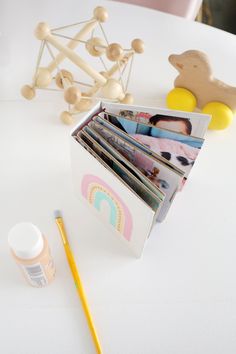 an open magazine holder sitting on top of a white table next to a pencil and some toys