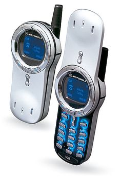 two cell phones sitting next to each other on top of a white surface with blue lights