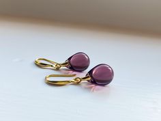 These simple, sophisticated earrings are great for everyday wear. With amethyst-toned Czech glass set against luxurious gold plated silver or sterling silver, these earrings are truly the perfect pair to add an unexpected pop of colour to your everyday essentials.  Presented in a beautiful vegan jewelry pouch, making a wonderful gift for loved ones or as a treat for yourself.  To select the colour seen in the main photo, please select 'E. AMETHYST PURPLE' from the drop-down menu. A D D I T I O N Elegant Purple Earrings For Everyday, Everyday Purple Drop Earrings, Sophisticated Earrings, Minimalist Silver Ring, Pouch Making, Vegan Jewelry, Earrings Everyday, Earring Box, Sterling Silver Drop Earrings