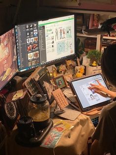 a woman sitting in front of two computer monitors on top of a desk with various items