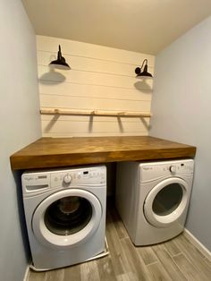 a washer and dryer in a room with two lights on the wall above them