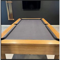 a pool table with a tv mounted on the wall behind it and an entertainment center in the background