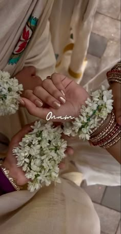 two people holding flowers in their hands