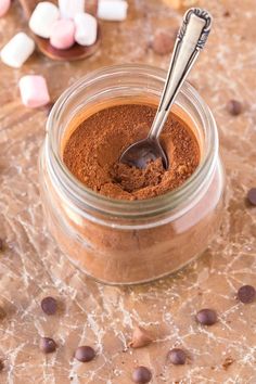 a jar filled with chocolate and marshmallows on top of a table