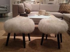 a living room filled with furniture and a coffee table covered in fluffy white furs