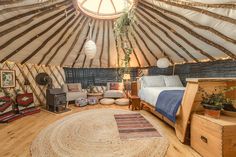 the inside of a yurt with a bed and rug