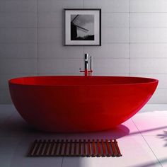 a red bath tub sitting on top of a white tiled floor