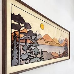 a painting hanging on the wall next to a window with mountains and trees painted on it