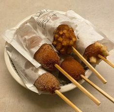 some food is sitting on a plate with chopsticks in it and wrapped in paper