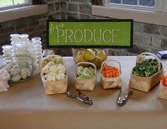 a table topped with baskets filled with fruits and veggies next to a sign that says fresh produce