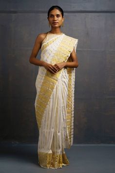 Ivory handwoven saree kasavu featuring stripe pattern all over with golden border. Comes with unstitched blouse piece. - Aza Fashions Festive White Pre-draped Saree With Cutdana, White Cotton Silk Pre-draped Saree For Festivals, White Cotton Silk Pre-draped Saree With Zari Work, White Pre-draped Saree With Zari Work, White Pre-draped Saree For Designer Wear, Elegant White Pre-draped Saree With Pallu, Elegant White Tissue Silk Pre-draped Saree, White Chanderi Pre-draped Saree With Zari Work, Off White Pre-draped Saree With Cutdana